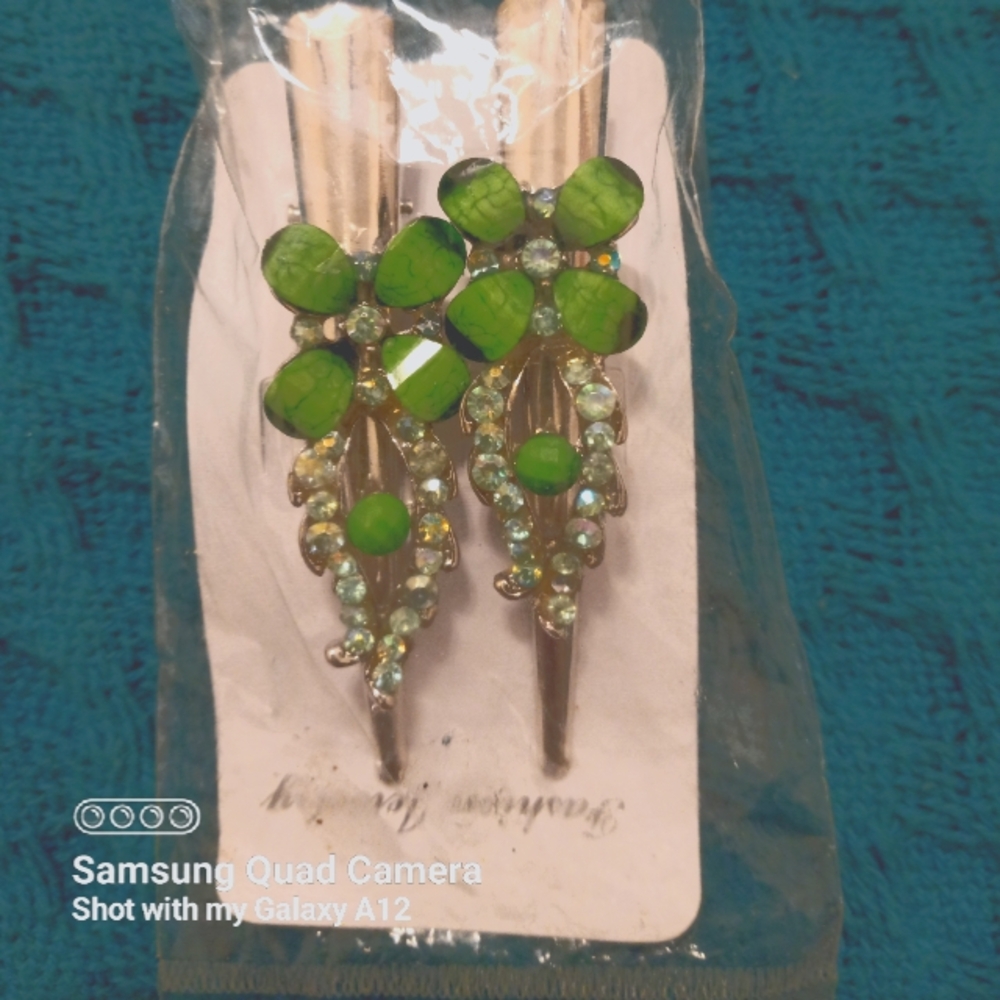 Package of 2 hair clips with green rhinestones.  Not name brand. Simply stylish